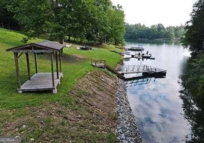 view of dock featuring a lawn and a water view