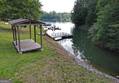 view of dock featuring a water view and a lawn