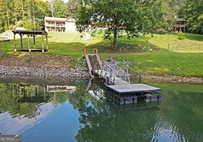 dock area with a water view and a lawn