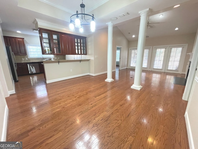 unfurnished living room with hardwood / wood-style floors, crown molding, decorative columns, and ceiling fan with notable chandelier