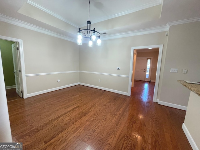 unfurnished dining area featuring a tray ceiling, crown molding, an inviting chandelier, and dark hardwood / wood-style flooring