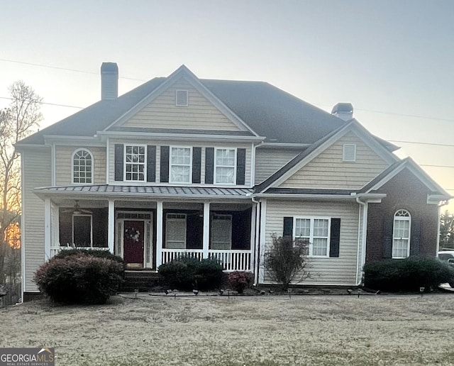 view of front of house featuring a porch and a chimney