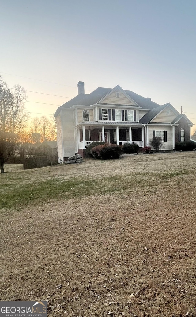 view of front facade featuring a porch and a yard