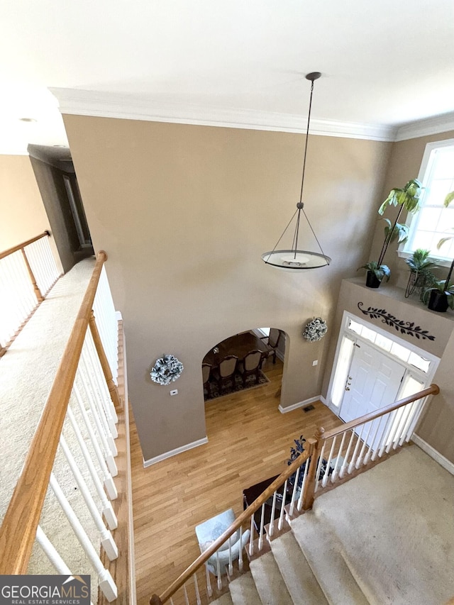 entryway featuring ornamental molding, stairway, wood finished floors, and baseboards