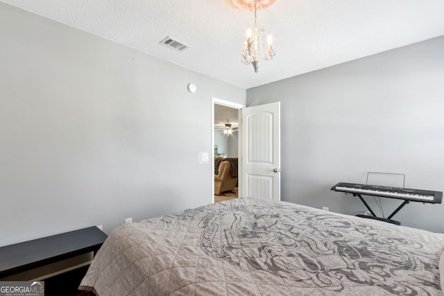 bedroom with a textured ceiling and a chandelier