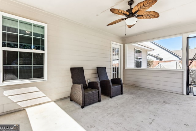 living area with crown molding and ceiling fan