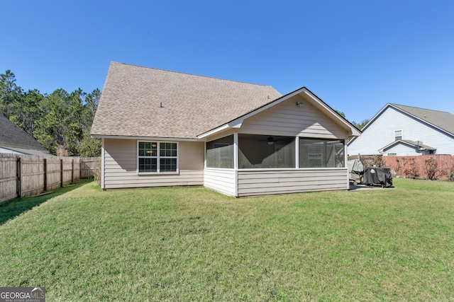 back of house featuring a lawn and a sunroom