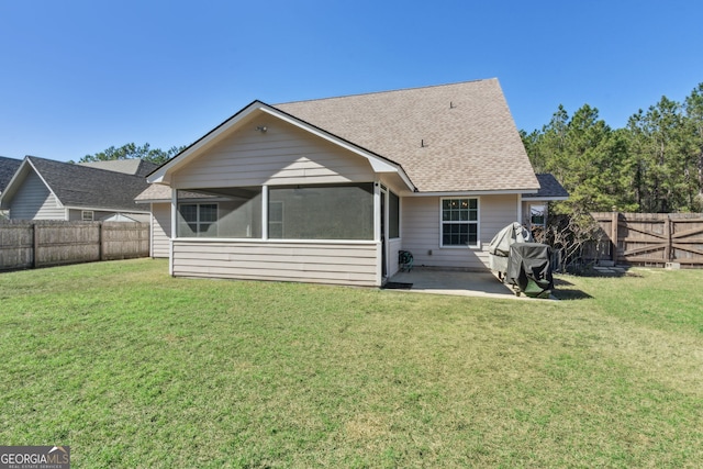 rear view of house with a yard, a patio, and a sunroom