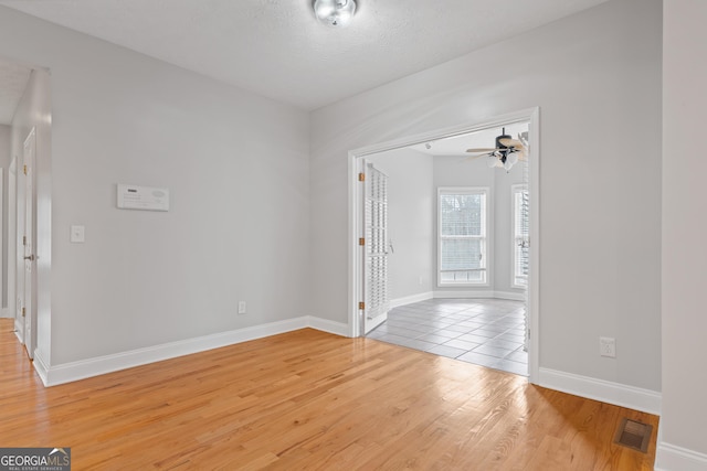 foyer featuring ceiling fan, light wood-type flooring, and a textured ceiling