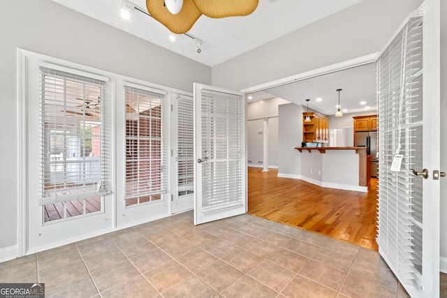 tiled empty room with rail lighting and ceiling fan