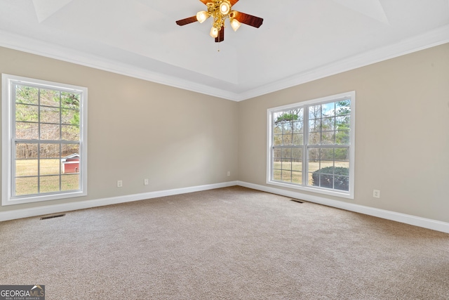 carpeted empty room featuring plenty of natural light, ceiling fan, and ornamental molding