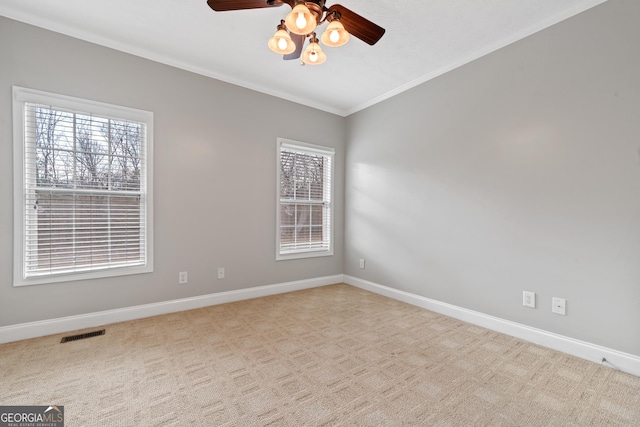 carpeted empty room featuring crown molding and ceiling fan