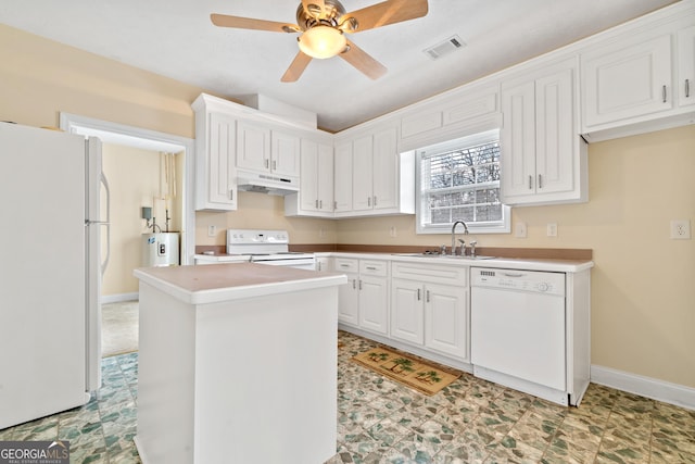 kitchen with white appliances, ceiling fan, a kitchen island, sink, and white cabinetry