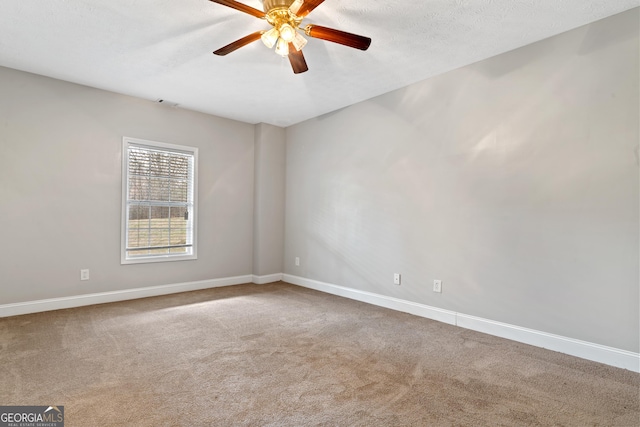 empty room with ceiling fan, carpet flooring, and a textured ceiling