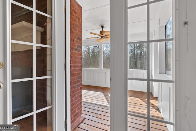 unfurnished sunroom featuring ceiling fan