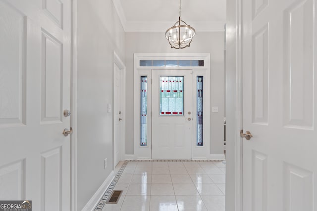 foyer entrance featuring ornamental molding, light tile patterned flooring, and an inviting chandelier