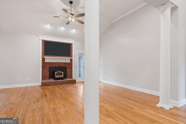 unfurnished living room featuring hardwood / wood-style floors, lofted ceiling, ceiling fan, crown molding, and ornate columns