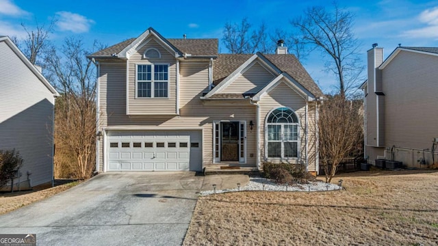 view of front property featuring a front yard, central AC unit, and a garage