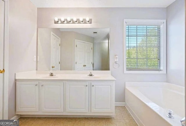 full bath featuring a sink, baseboards, a bath, and double vanity