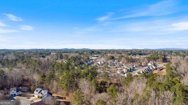 birds eye view of property with a mountain view and a wooded view