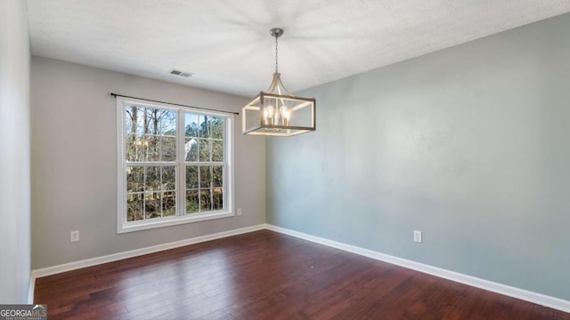 unfurnished dining area with dark wood-type flooring, visible vents, and baseboards