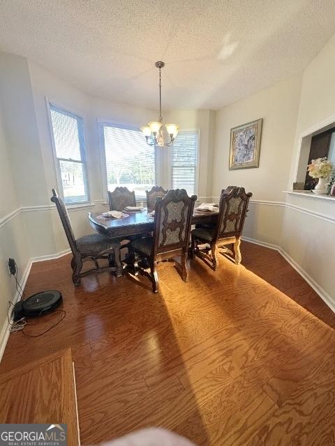 11 Plantation Dr, Swainsboro, GA 30401 - dining room featuring baseboards, a textured ceiling, a chandelier, and wood finished floors