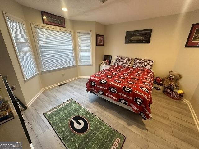 11 Plantation Dr, Swainsboro, GA 30401 - bedroom with light wood-type flooring, multiple windows, and baseboards