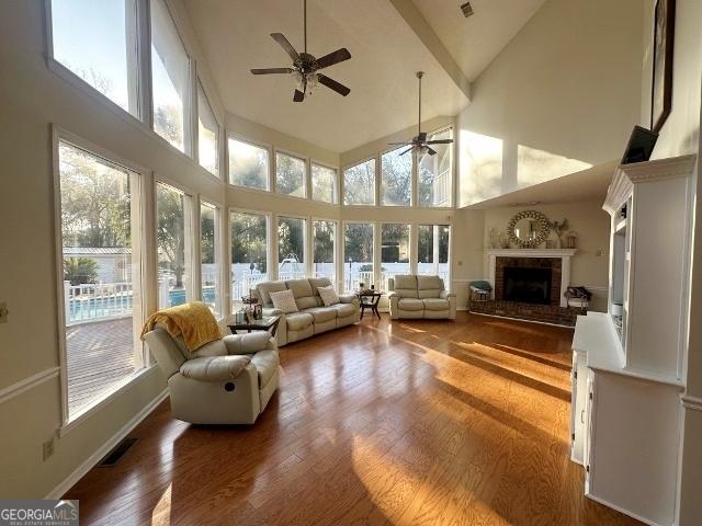 sunroom featuring a wealth of natural light, a fireplace, and visible vents