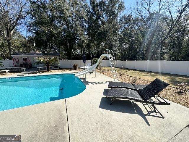 11 Plantation Dr, Swainsboro, GA 30401 - view of swimming pool with a patio, a water slide, a fenced backyard, and a fenced in pool