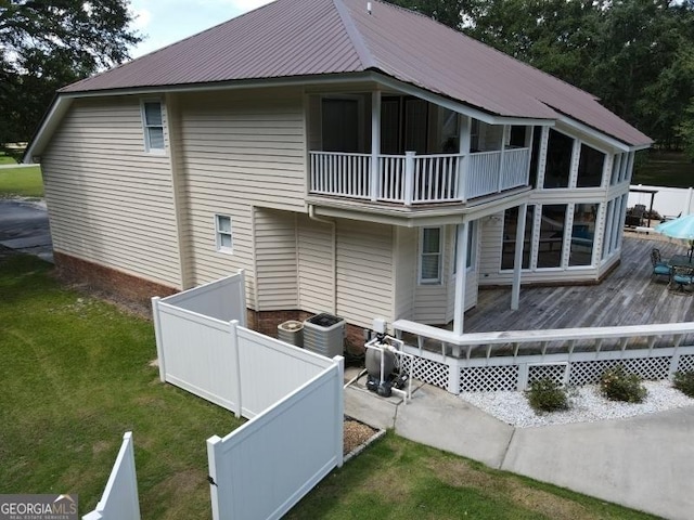 11 Plantation Dr, Swainsboro, GA 30401 - back of property featuring central AC unit, a balcony, metal roof, fence, and a wooden deck