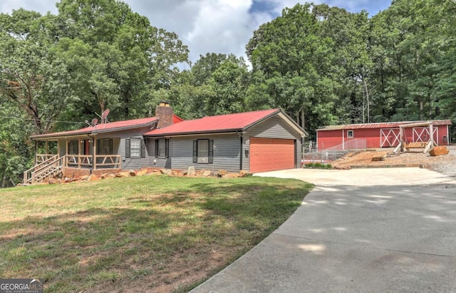 ranch-style home with covered porch, a front lawn, and a garage