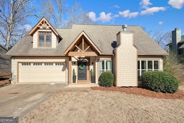 view of front of house with concrete driveway, roof with shingles, a chimney, and an attached garage