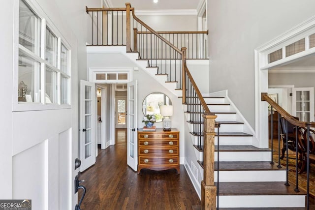 entryway featuring dark hardwood / wood-style flooring, ornamental molding, a high ceiling, and french doors