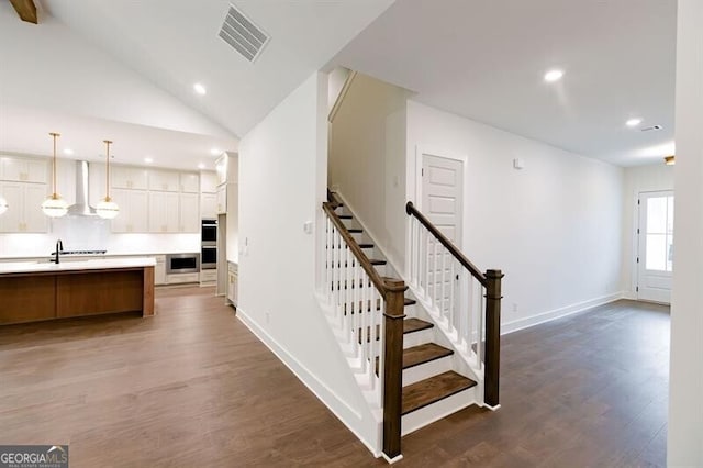 interior space featuring lofted ceiling, wood-type flooring, and sink