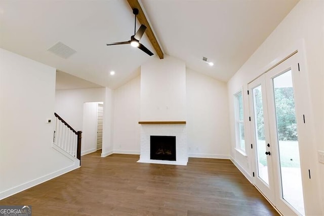 unfurnished living room with french doors, high vaulted ceiling, a fireplace, dark hardwood / wood-style flooring, and beamed ceiling