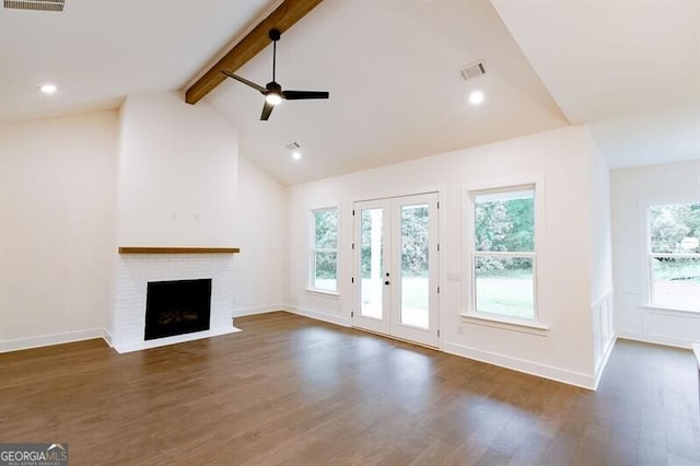 unfurnished living room with ceiling fan, a wealth of natural light, beamed ceiling, and dark hardwood / wood-style flooring