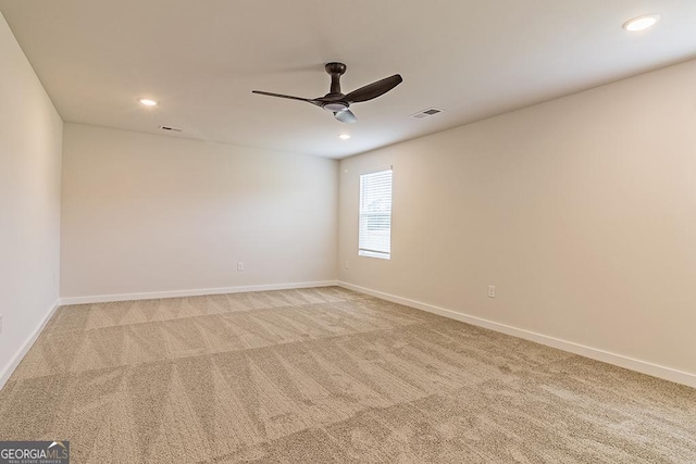 empty room with light carpet, ceiling fan, visible vents, and baseboards