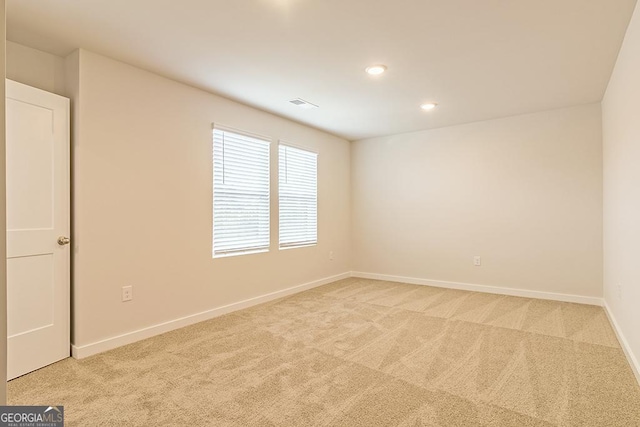 spare room with light carpet, recessed lighting, visible vents, and baseboards