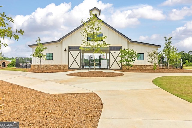 view of building exterior with concrete driveway and fence