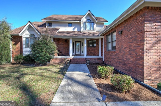 view of front of home featuring covered porch and a front lawn