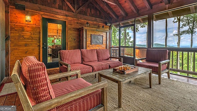 sunroom with a healthy amount of sunlight, lofted ceiling with beams, and wood ceiling