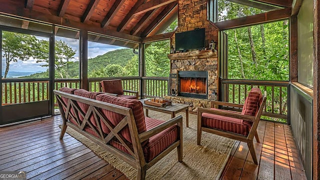 sunroom featuring wood ceiling, lofted ceiling with beams, and a fireplace