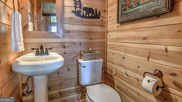 bathroom featuring toilet and wood walls