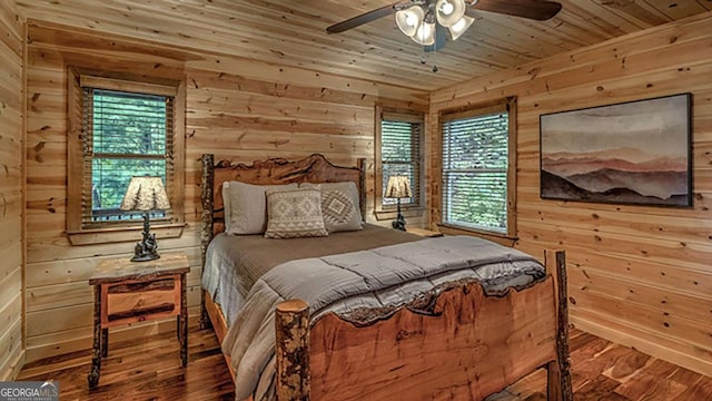 bedroom with wooden ceiling, hardwood / wood-style flooring, and wooden walls