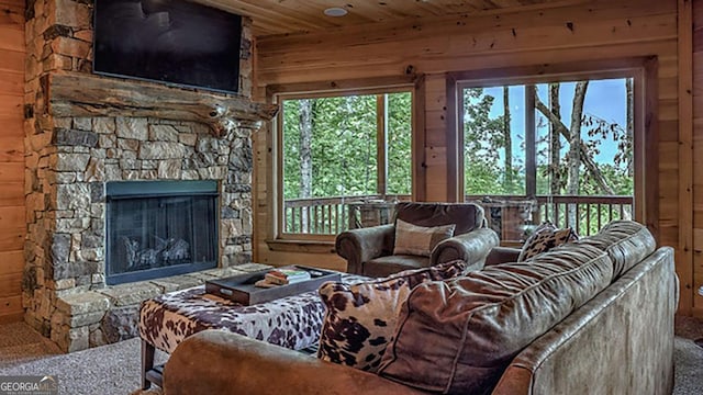 living room featuring a fireplace, carpet flooring, wood walls, and wooden ceiling