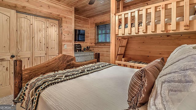 bedroom with ceiling fan, wood ceiling, and wood walls