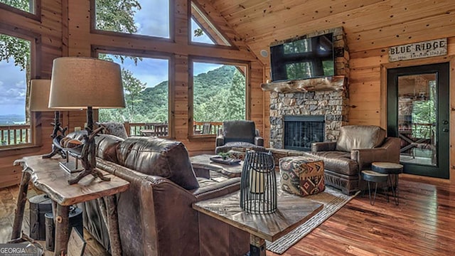 living room with hardwood / wood-style flooring, wooden walls, high vaulted ceiling, wood ceiling, and a fireplace