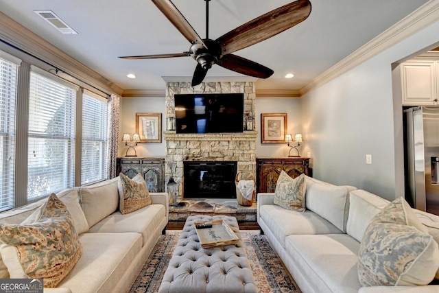 living room featuring a fireplace, crown molding, and ceiling fan