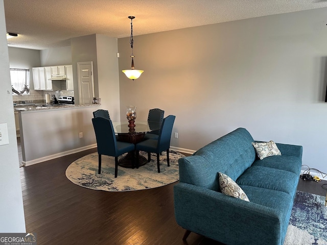 dining area with dark hardwood / wood-style flooring and a textured ceiling