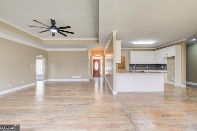 kitchen with white cabinets, arched walkways, and open floor plan